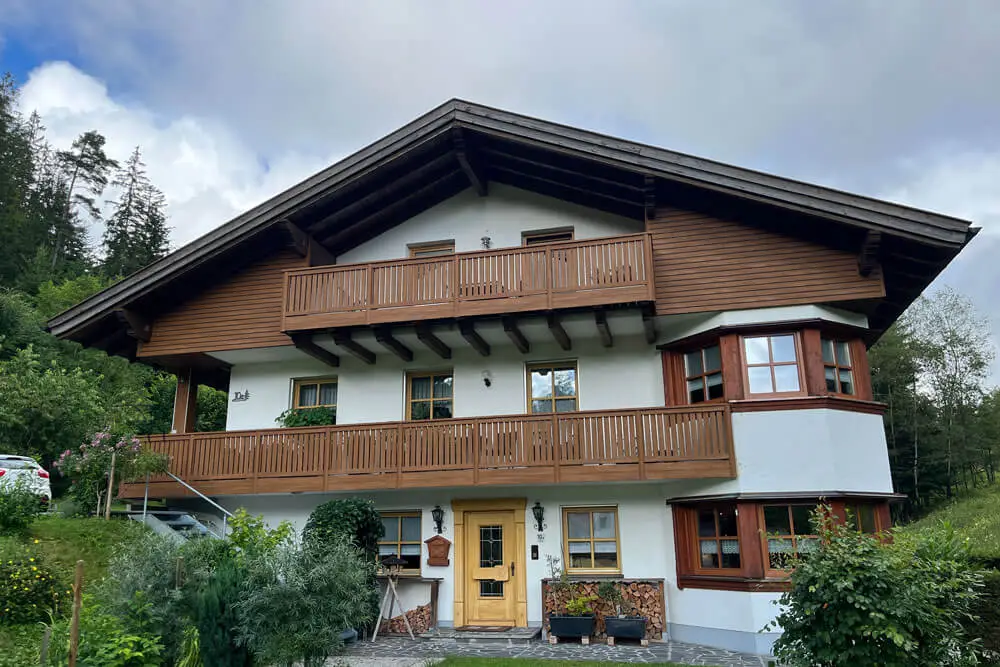 Dreistöckiges Haus mit Objektbalkon Nr. 1 in Dekor Honey Oak Supermatt und passender Kunststoff-Fassadenverkleidung.