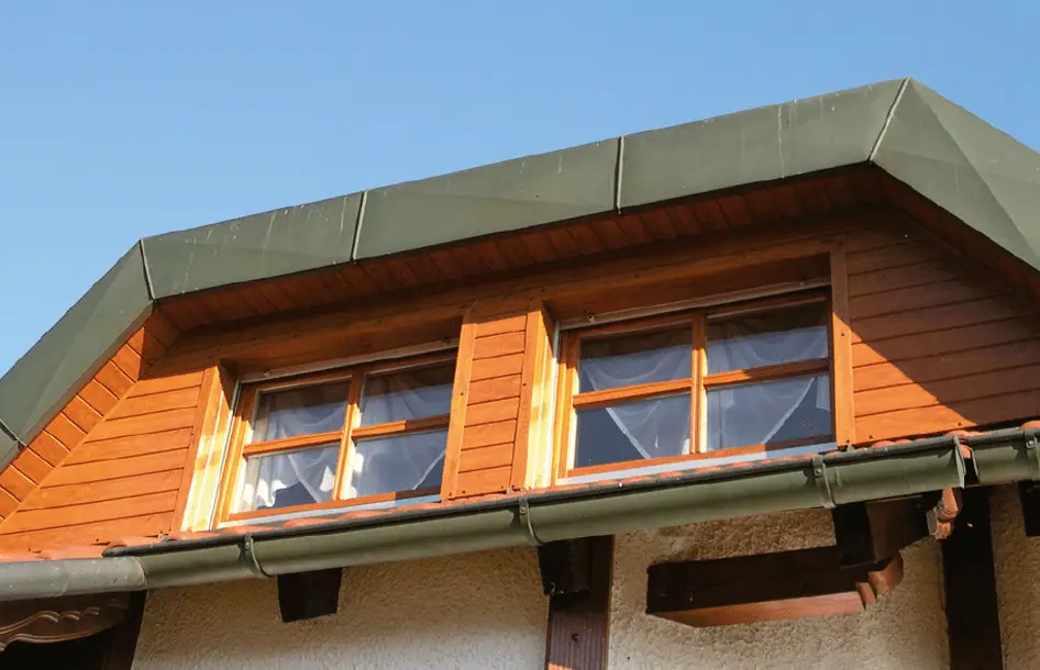 Fassadenverkleidung im Dekor Golden-Oak an Dachgaube mit 2 Fenstern und verblechtem Giebel