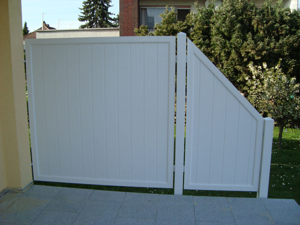 Weißer Sichtschutz Ecoline mit abgeschrägtem Abschlusselement auf Terrasse vor Garten